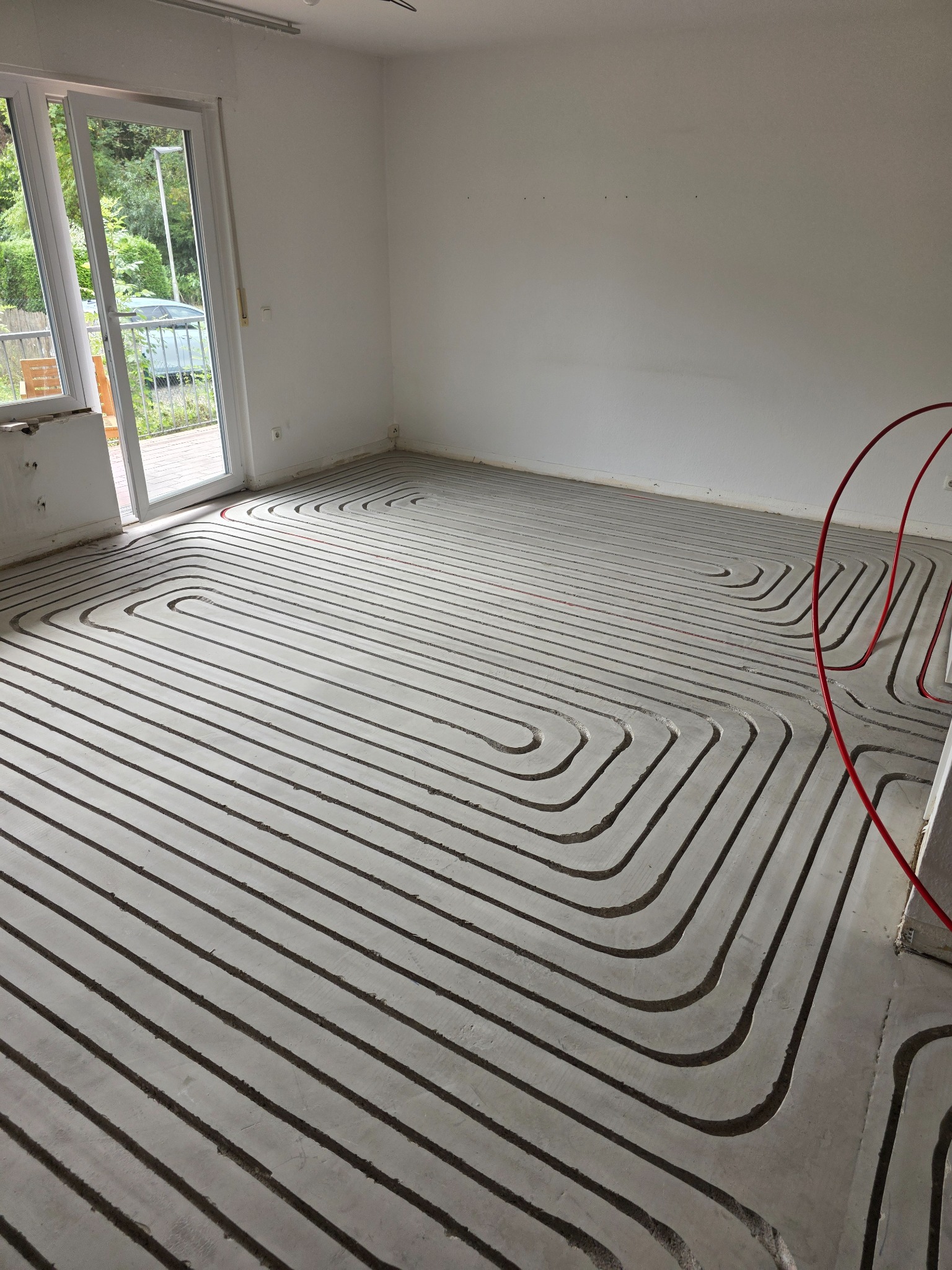 Gefräste Heizkanäle vor einer Fensterfront und einer geöffneten Terrassentür
