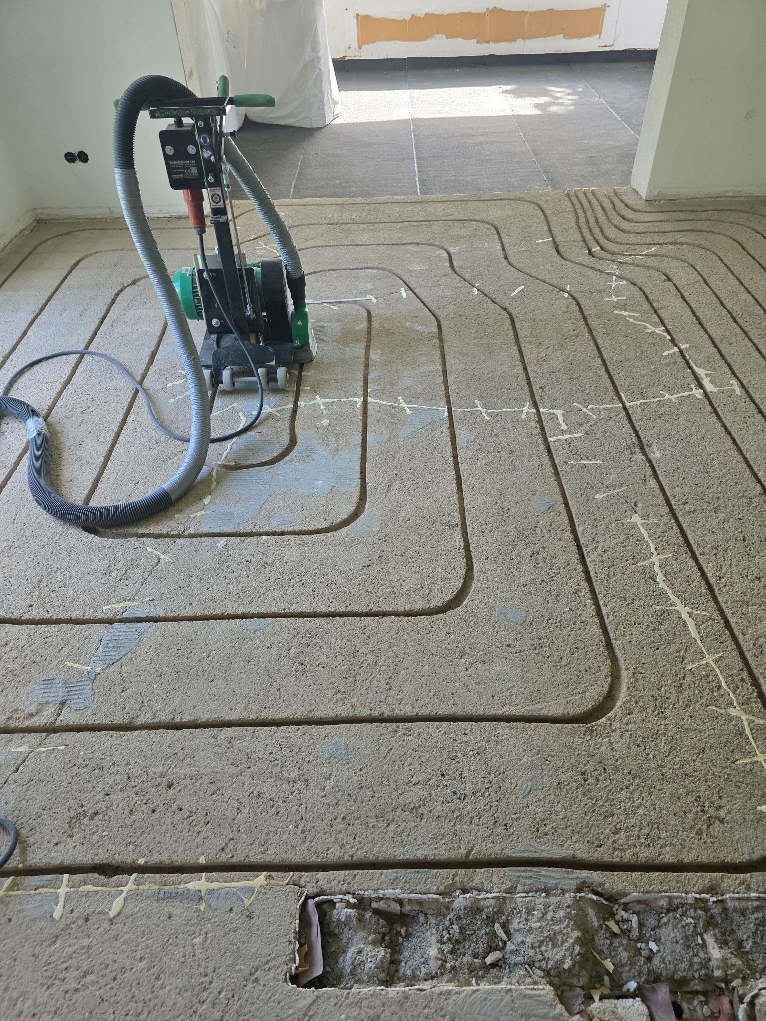 Fräsmaschine mit Staubabsaugung auf einem bereits gefrästen Estrichboden