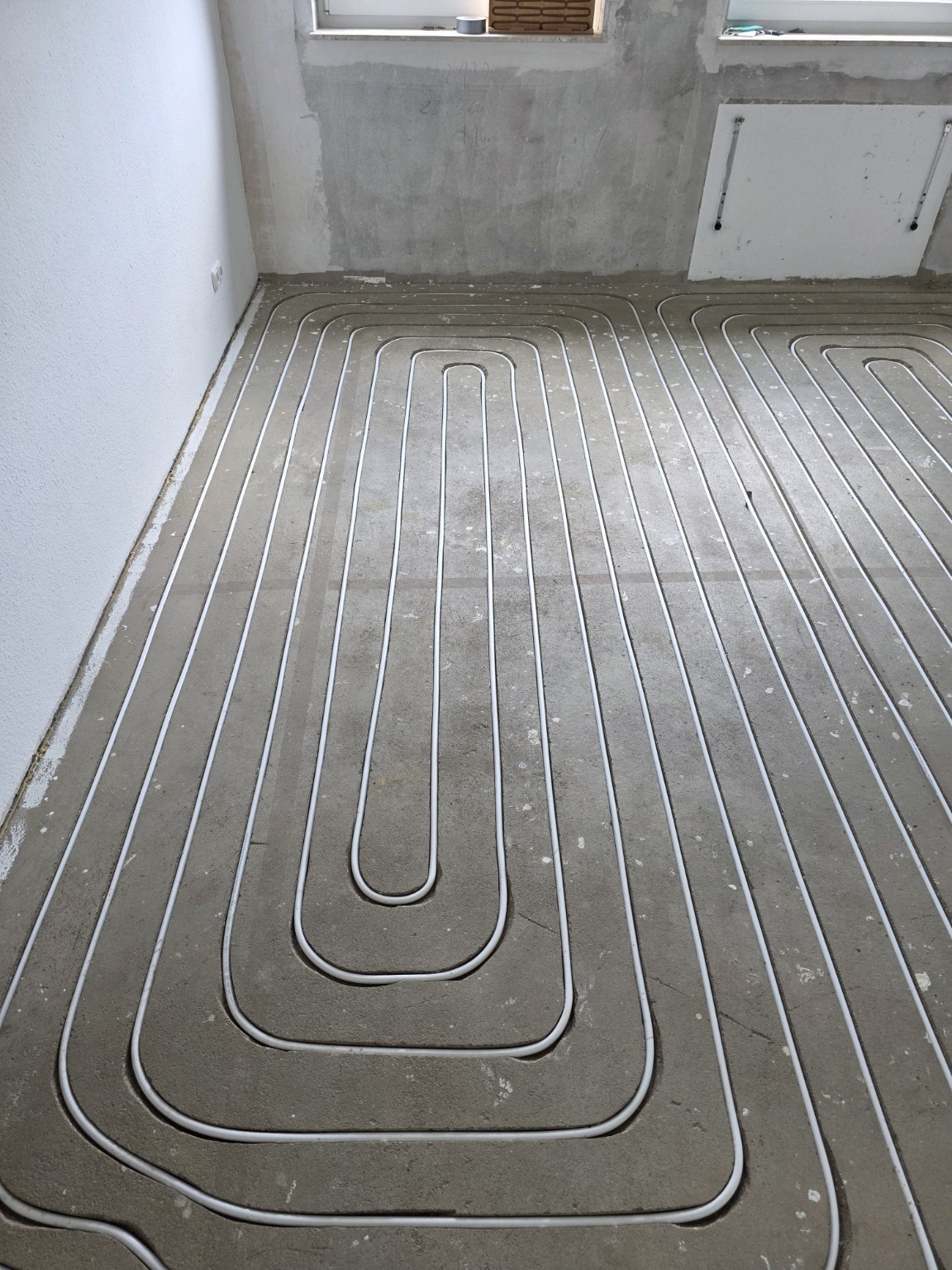 Heizungsrohre in den gefrästen Kanälen